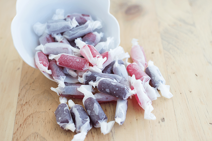 assorted pieces of Homemade Kool-aid Taffy rolled and wrapped in waxed paper