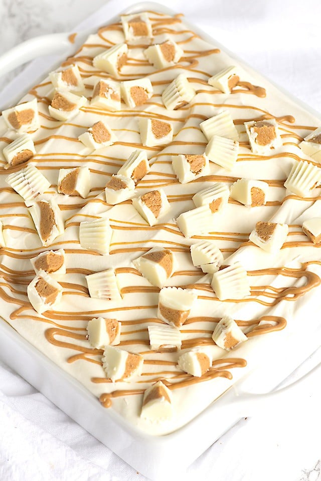 No Bake White Chocolate Peanut Butter Dessert - layers of buttery pound cake, peanut butter mousse, white chocolate ganache and topped with white chocolate peanut butter cups! This is the perfect summer treat !