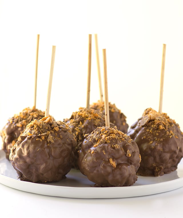 Chocolate Covered Peanut Butter Popcorn Balls - gooey peanut butter marshmallow popcorn balls coated with chocolate and sprinkled with butterfinger bits!