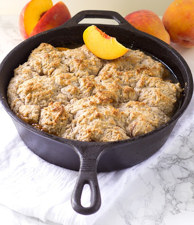 Skillet Peach Cobbler - fresh peaches sliced thrown in a skillet and topped with the perfect biscuit. This tastes amazing warmed with a scoop of vanilla ice cream!