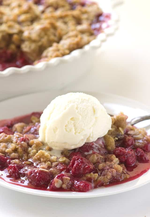 Raspberry Crisp - Grab a bowl and scoop some raspberry crisp in it and top it with some ice cream! The crisp topping is loaded with brown sugar and oatmeal. This is the perfect end of summer dessert!