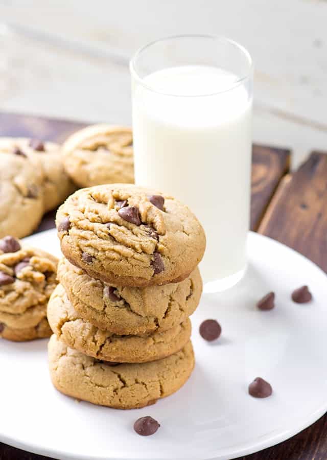 thick soft peanut butter chocolate chip cookies next to a glass of milk