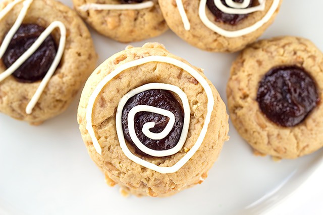 Apple Toffee Thumbprint Cookies - apple butter filled thumbprint cookies with bits of toffee in them. Don't forget the cream cheese drizzle to finish the cookies off!