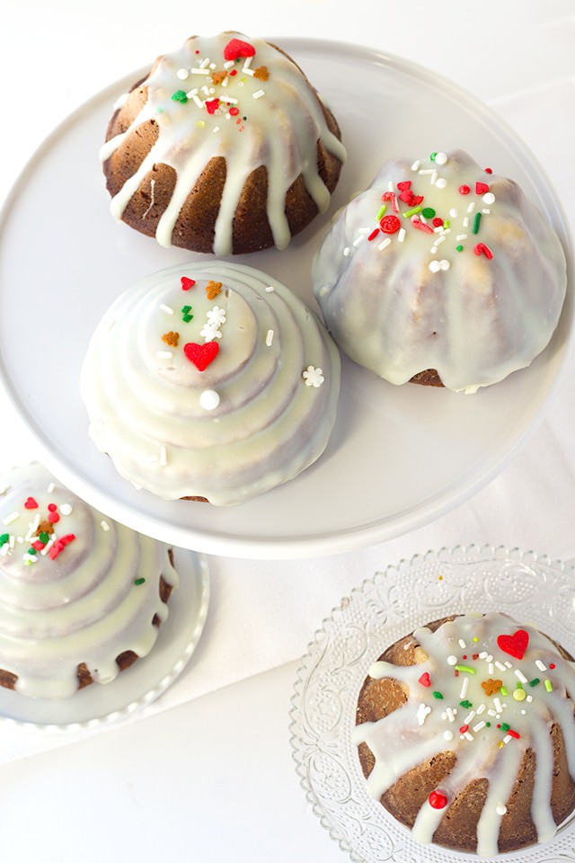 Gingerbread Bundt Cakes - the perfect little cakes for Christmas, They're full of molasses , spices, and the perfect gingerbread flavor! Top the cakelettes with a white chocolate ganache and sprinkles for the finishing touch.