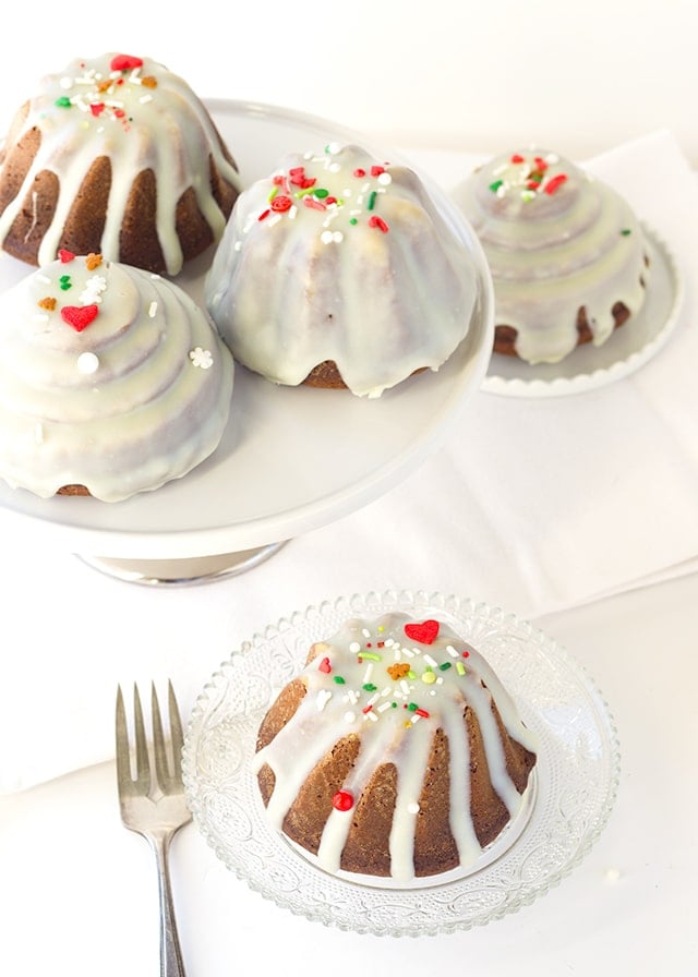 Gingerbread Bundt Cakes - the perfect little cakes for Christmas, They're full of molasses , spices, and the perfect gingerbread flavor! Top the little cakes with a white chocolate ganache and sprinkles for the finishing touch.