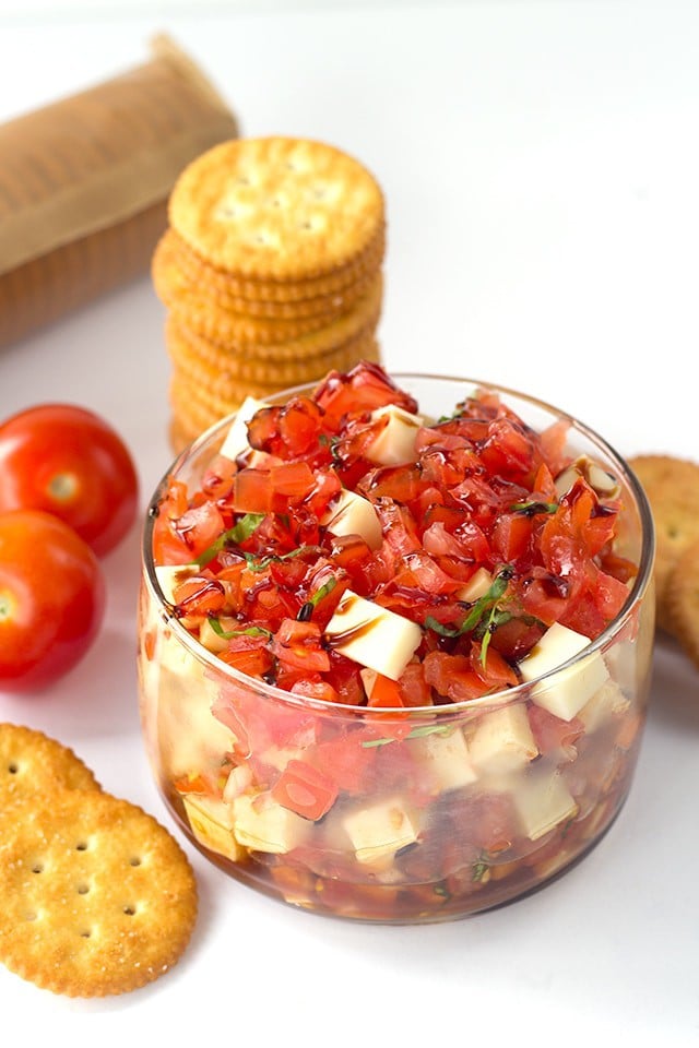 Caprese Salsa - finely diced tomatoes, shallots, basil and mozzarella tossed in a balsamic glaze and scooped up with some buttery ritz crackers!