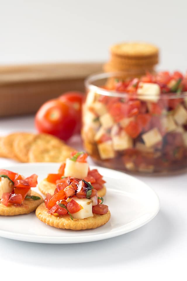 Caprese Salsa - finely diced tomatoes, shallots, basil and mozzarella tossed in a balsamic glaze and scooped up with some buttery ritz crackers!